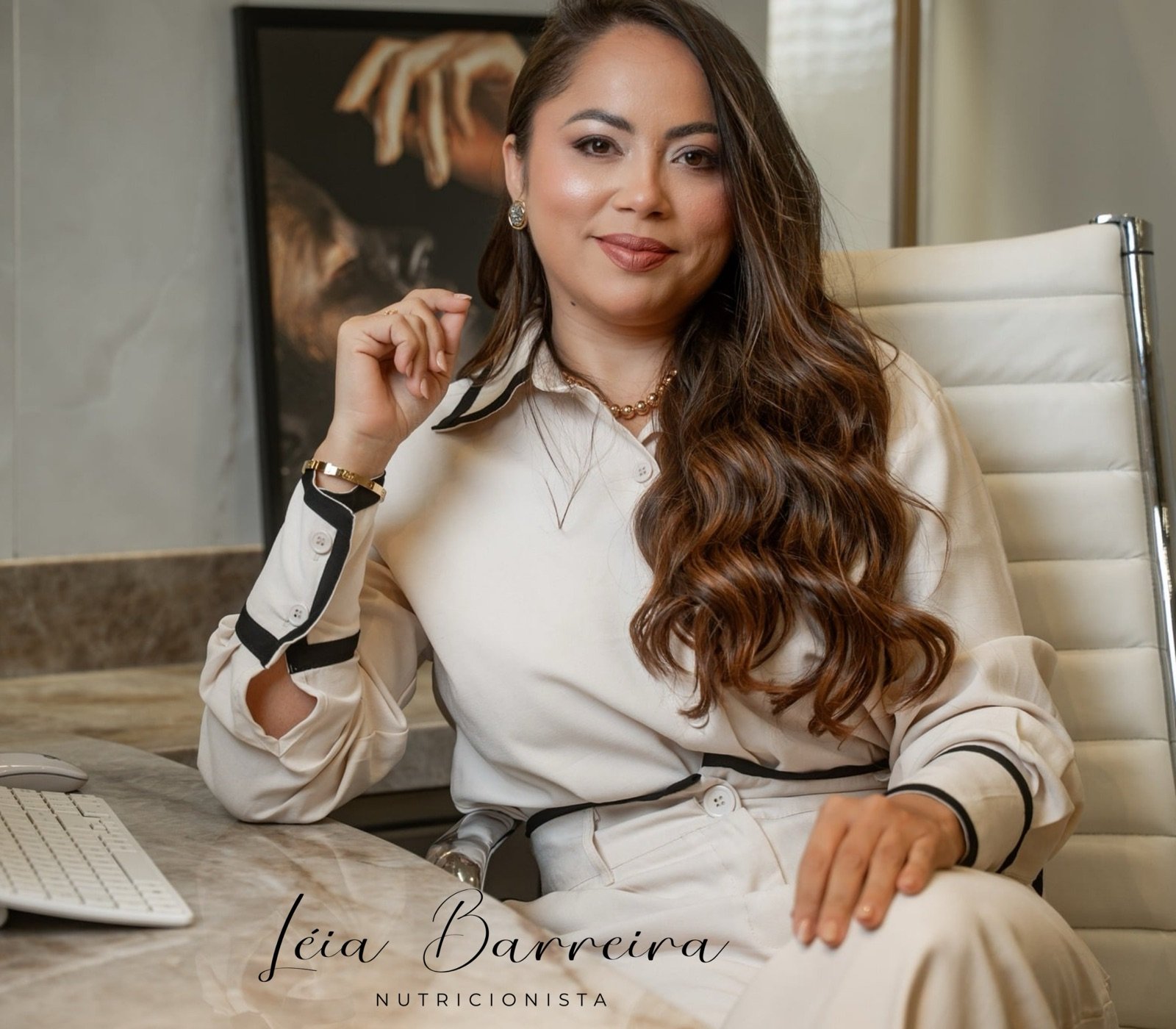 Léia Barreira, nutricionista, sentada à mesa do consultório